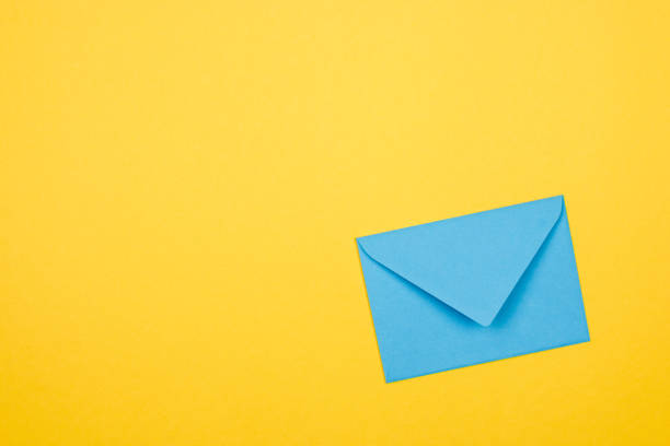istock blue envelope in corner of a yellow background 1200929997