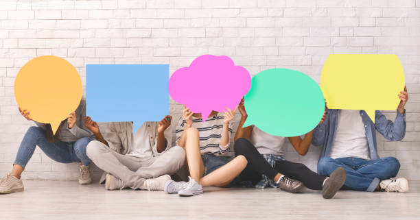 istock Group of students covering faces with colorful speech bubbles 1200931708