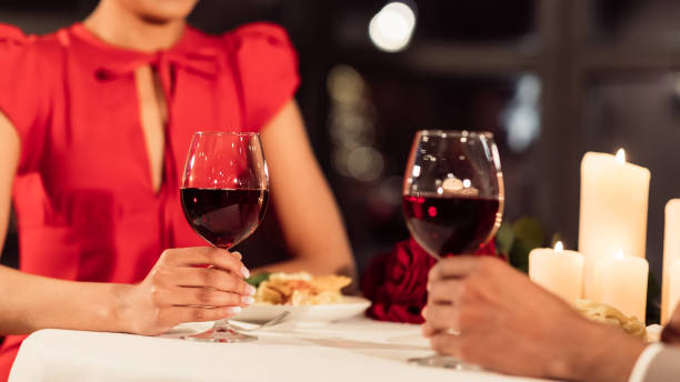 istock Unrecognizable Couple Holding Glasses Having Dinner In Restaurant, Panorama, Cropped 1200931848