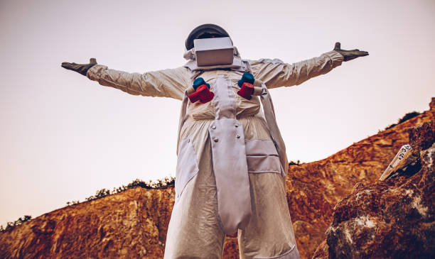istock Man cosmonaut with arms outstretched on Mars 1200932224