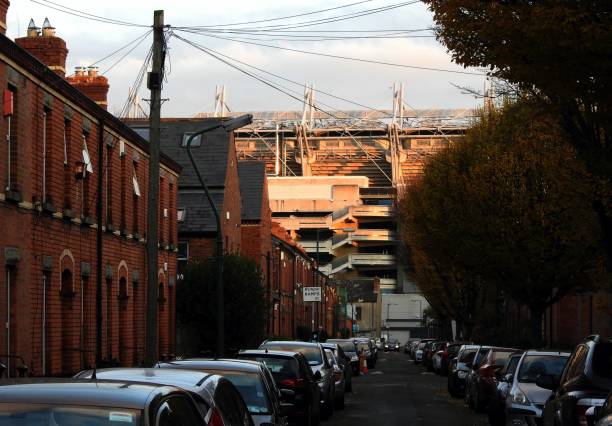 A residential, car filled, side street in Drumcondra, with Croke Park GAA stadium in the far distance.