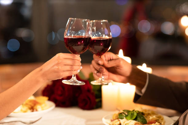 istock Lover's Hands Clinking Glasses Having Date In Restaurant 1200933476