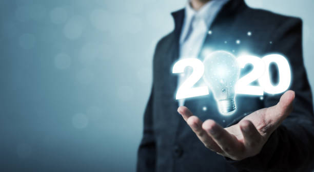 istock Businessman hand holding light bulb with year 2020 idea innovation technology concept 1200934104