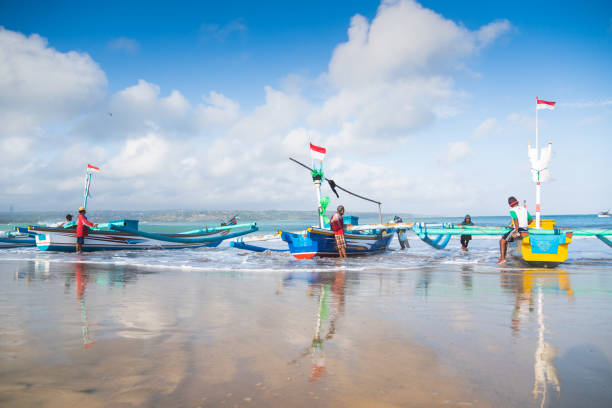 Bali, Indonesia - July 28, 2017: Traditional fisherman catching fish  and preparing boats for work  in Kedonganan Beach, Bali, Indonesia.
