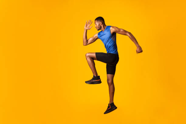 Handsome black sportsman walks highly lifting knees