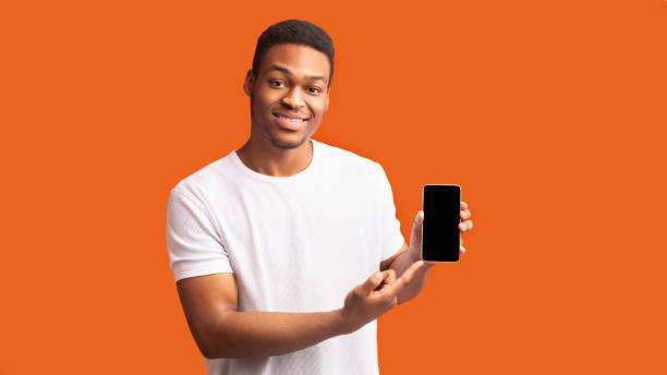 istock Afro guy showing blank black mobile phone screen 1200935504