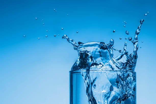 istock Water splash in a glass cup on a blue background 1200935564