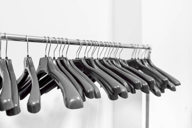 istock Empty plastic hangers hanging in a wardrobe for clothes 1200935619