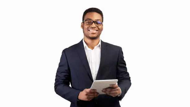 Photo of Smiling black guy standing with tablet at studio