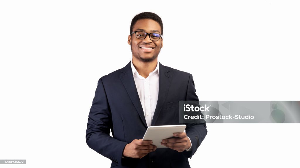 微笑的黑人家夥站在平板電腦在工作室 - 免版稅白色的背景圖庫照片