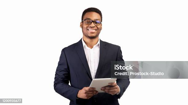 微笑的黑人家夥站在平板電腦在工作室 照片檔及更多 白色的背景 照片 - 白色的背景, 男商人, 非裔美國人種