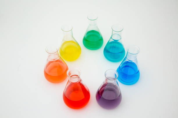 istock Scientific laboratory glass erlenmeyer flask filled with colorful liquid forming rainbow on white background. 1200935909