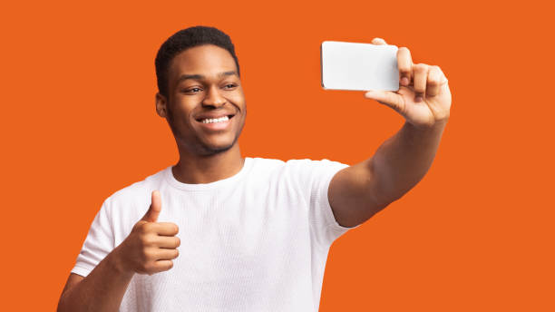 istock Headshot of afro guy taking selfie at studio 1200935934