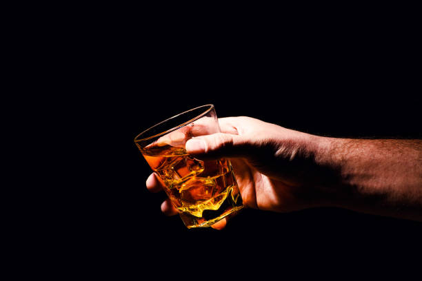 istock Whiskey glass in a hand of a man 1200937449