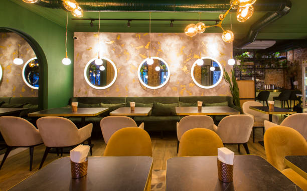 istock Modern restaurant interior with tables and sofas, light green walls 1200937674