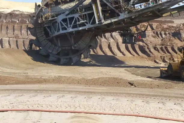 The work of a bucket wheel excavator in a quarry. Ore mining in a quarry.