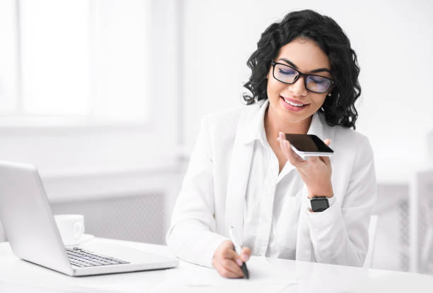 istock Smiling hispanic woman using voice assistant on phone 1200938924