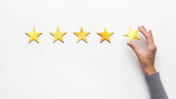 Photo of Woman hand giving and rating with five stars gold symbol