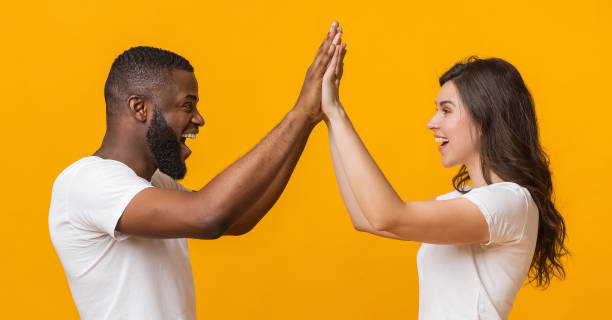 istock Overjoyed interracial couple giving high-five to each other, rejoicing victory 1200939519
