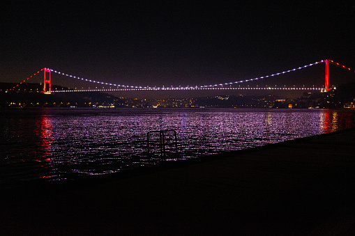 The lights of the bridge are reflected in the waters