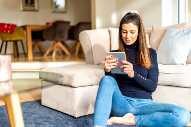 istock Attractive woman with digital tablet relaxing at home 1200945825