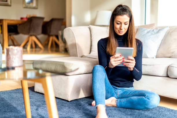 istock Attractive woman with digital tablet relaxing at home 1200945828
