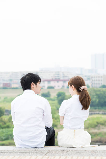 istock Couple sitting and talking outdoors with beautiful scenery 1200946492