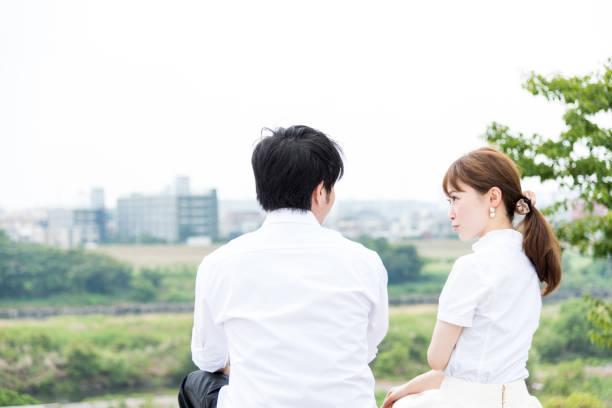 istock Couple sitting and talking outdoors with beautiful scenery 1200946503