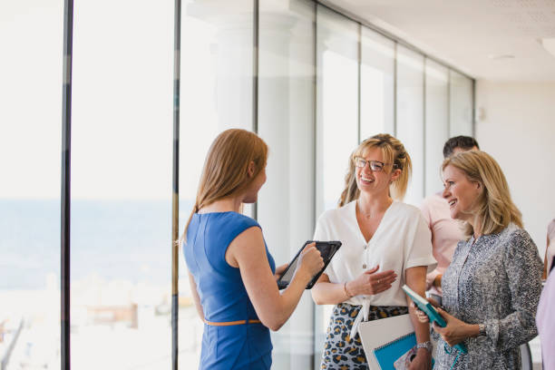 Confident female colleagues collaborating at work event