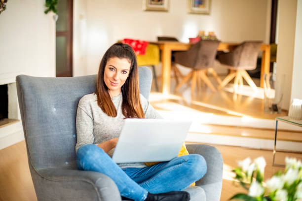 istock Casual businesswoman using laptop while working online from home 1200948485