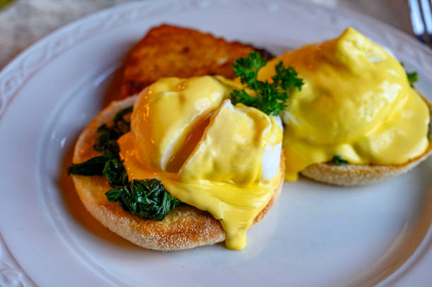 istock Weekend vegetarian brunch in Scotland with two eggs benedict on homemade muffuns with spinach and yellow hollandaise sauce. 1200949193
