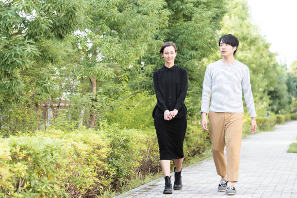 istock Men and women walking on the sidewalk where fresh green is refreshing 1200949512
