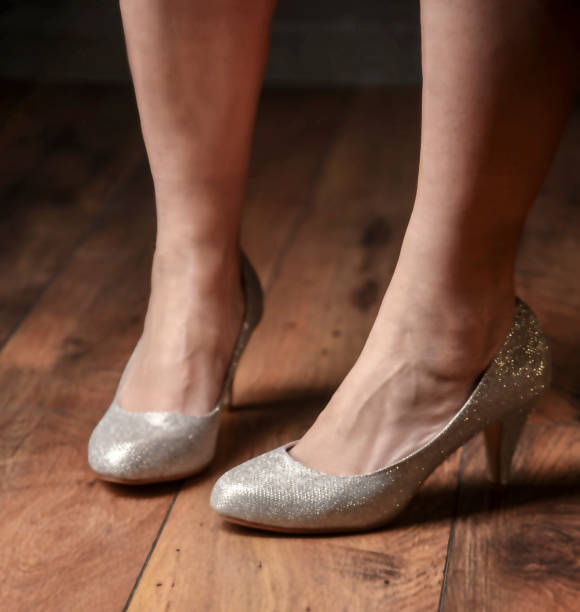 istock Woman's foot in high heels shiny shoes 1200949771