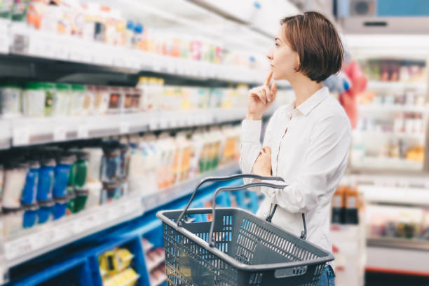 スーパーマーケットで買い物をする若い女性 - ショッピング ストックフォトと画像