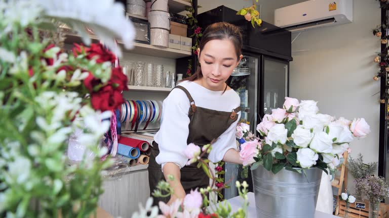 Owned florist flower Asian woman inside the shop to prepare for the sale, a Japanese woman with professional florists, flower shops in the city, small business concept.