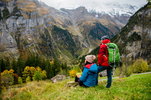 murren, asian young couple on a hiking trip in alps European mountain at autumn season