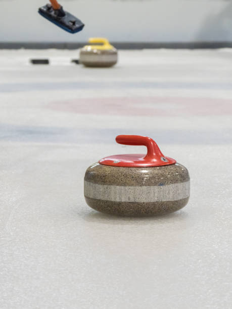 istock curling rocks on a white and blue rink. 1200951494