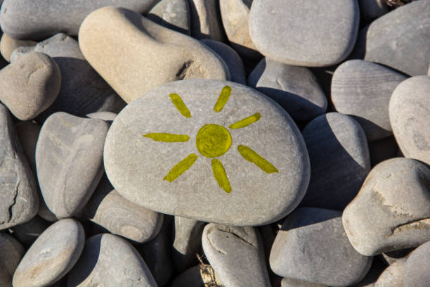 istock Bright sun painted on pebble. Pebbles background. 1200953589