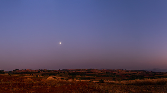 vast scenery of agricultural landscape on summer season with moon at dusk, Ban Chi Ba Bo, Phop Pra, Tak, Thailand
