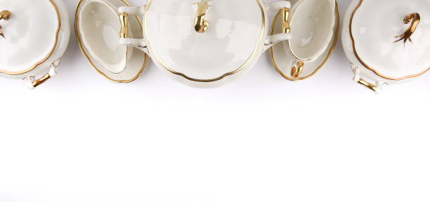 backdrop of porcelain tableware with gilding on a white background flat lay with copy space