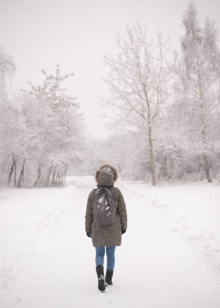 istock Woman walking in forest during snowfall 1200956528