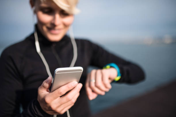 istock A young sportswoman with smartphone standing outdoors on beach. 1200961453