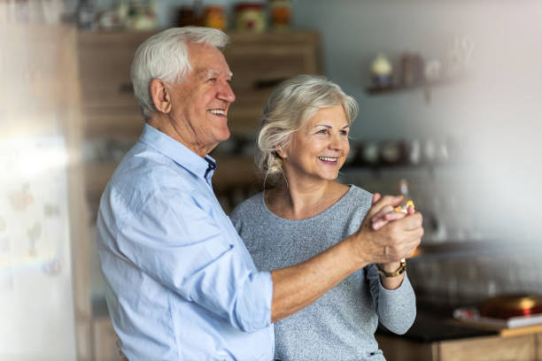 istock Senior couple dancing together in their home 1200962144