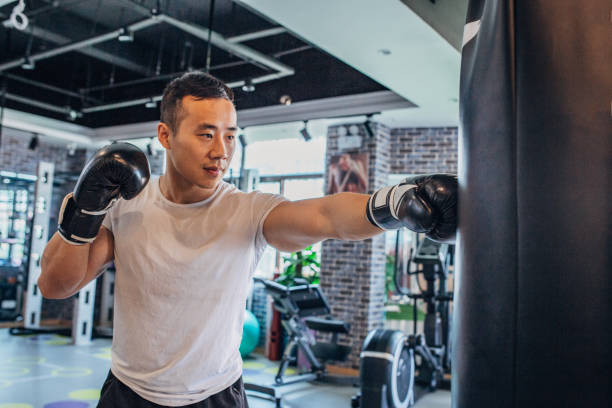 istock Young man is punching boxing bag 1200962969