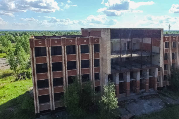 istock An old abandoned high rise building, overgrown with trees and gr 1200963045