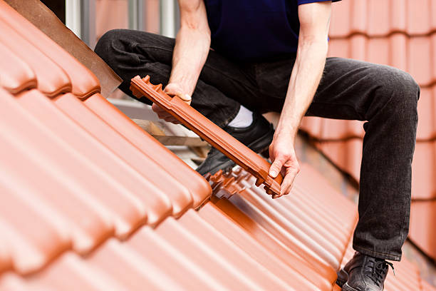 Tiler covering roof with new tile