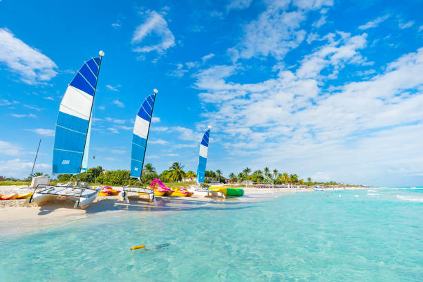 美麗的海景與清澈的綠松石水。帆船停泊在沙上。美麗的海灘巴拉德羅在古巴一個陽光明媚的夏天 - 古巴 個照片及圖片檔