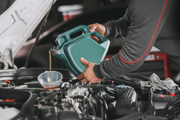 Photo of Pouring oil to car engine.