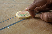istock Person ready to strike the coins in carrom board game. Multiplayer board game with good fun time. 1200969204