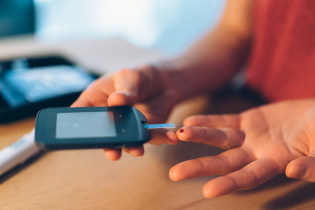 controlar la diabetes en casa con glaucometer - glaucometer fotografías e imágenes de stock